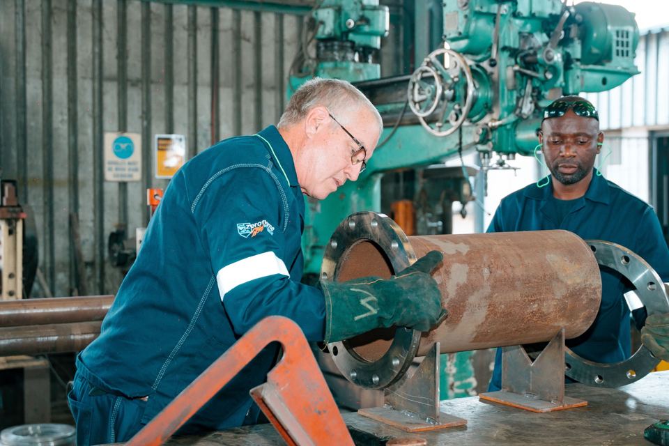 Two fitters inspecting a flanged pipe section in the Bronzeback workshop